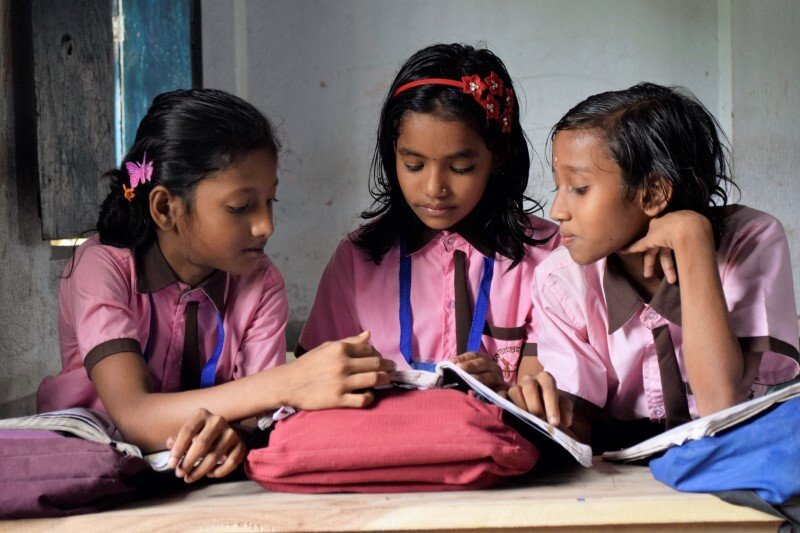 India Schoolgirls look at a book