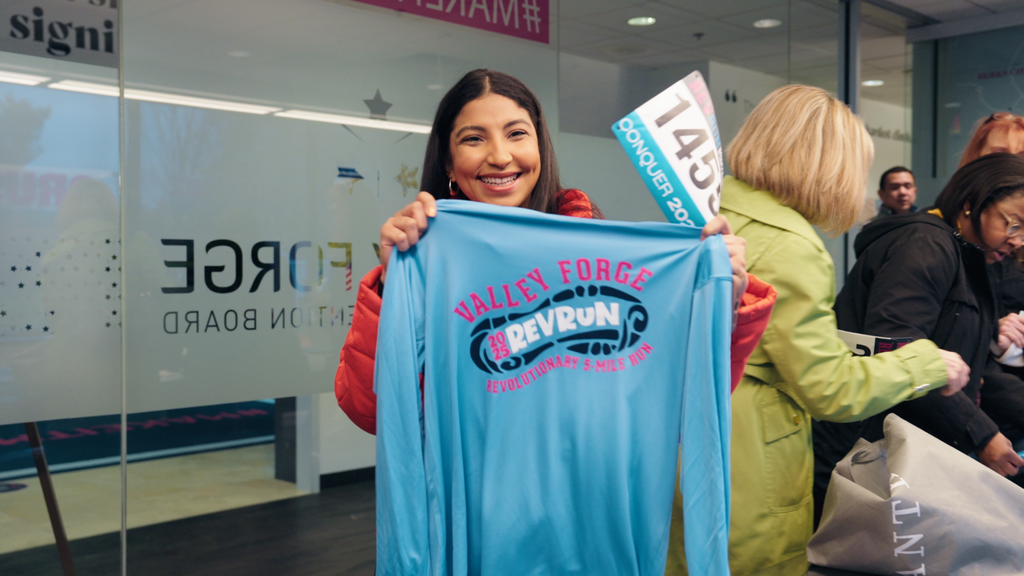 Influencer, Cass Matthews, holds up her shirt at packet pickup 