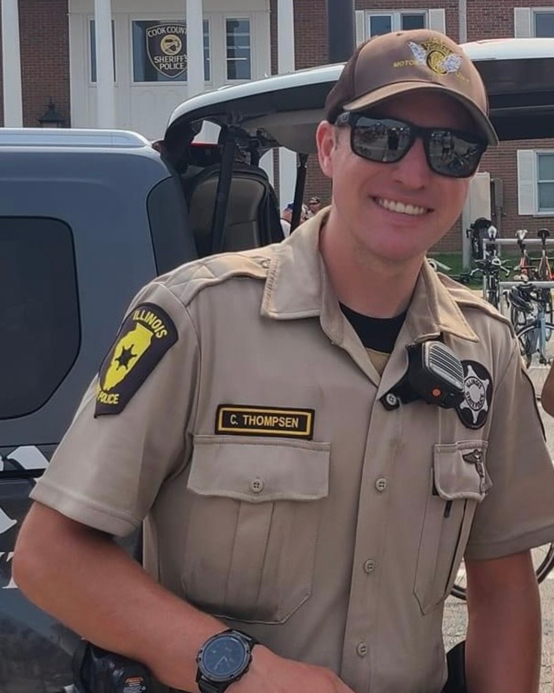 Image of Trooper Corey S. Thompsen smiling in a tan Illinois State Police uniform and sunglasses.