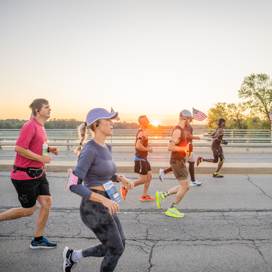 runners with sunset on bridge