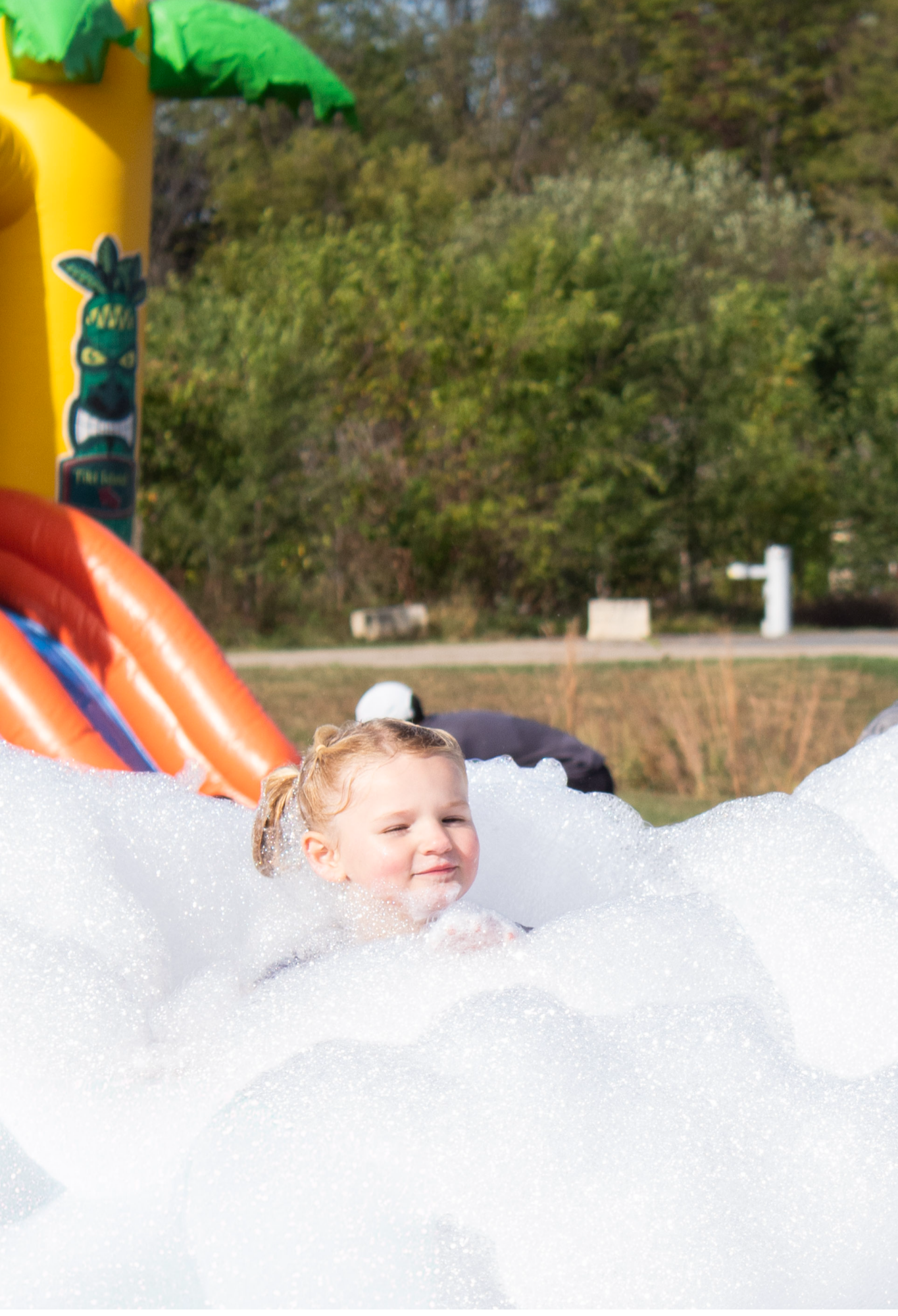 Girl playing in the foam at the Sensory Walk & Run Post Party