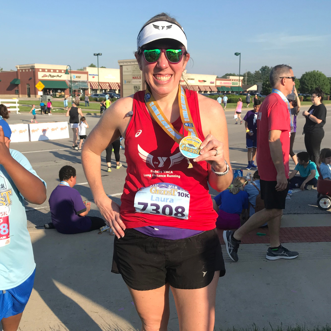 laura gropp posing with her medal at geist 10k