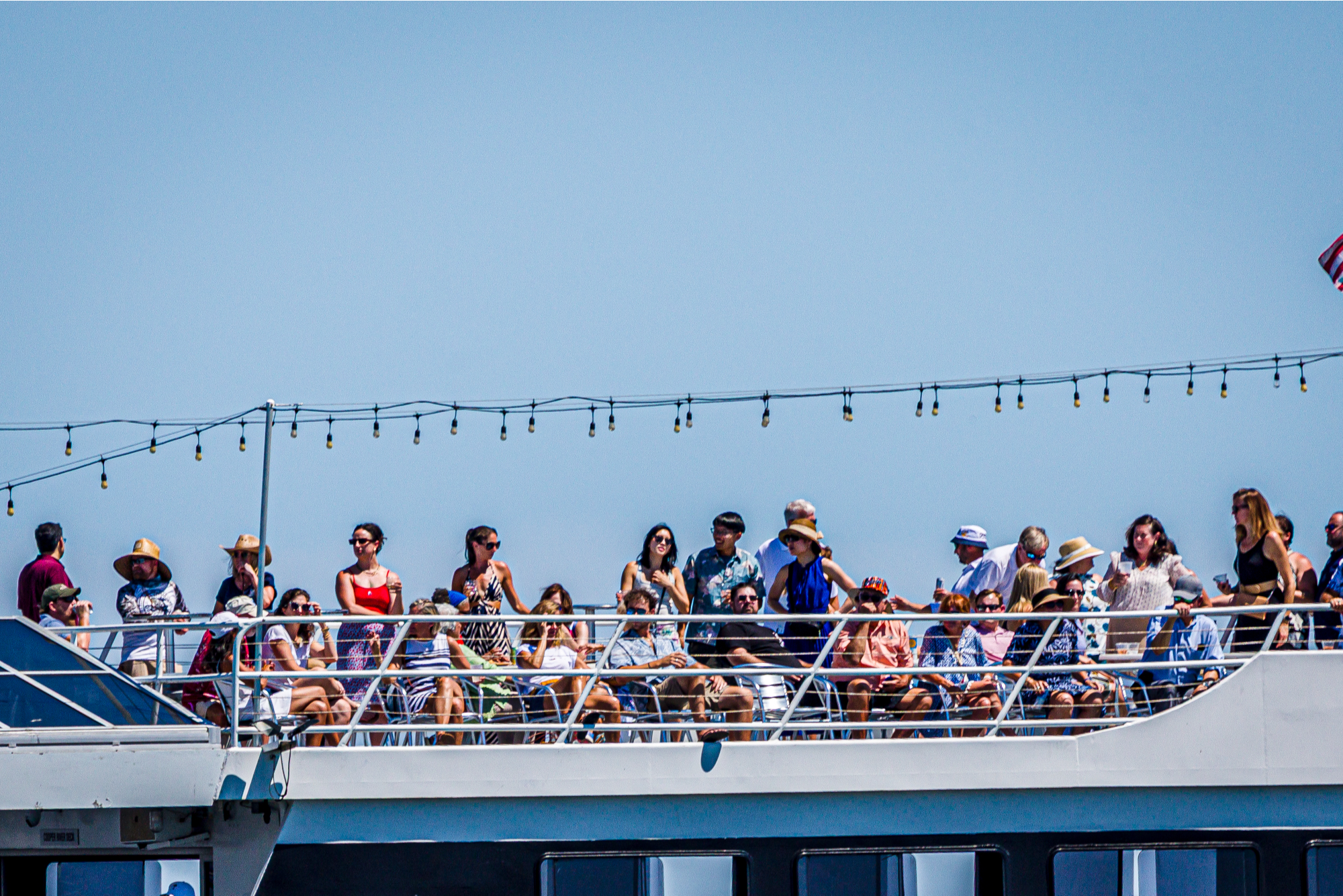 People enjoy the regatta on the top deck of the spectator boat