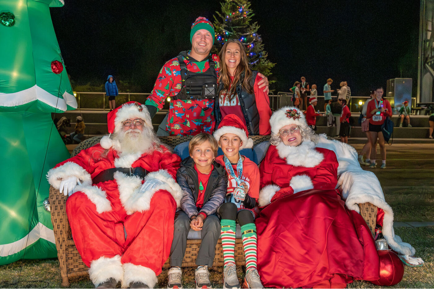 A family poses with Santa and Mrs. Claus at Dashing Thru the Glow.