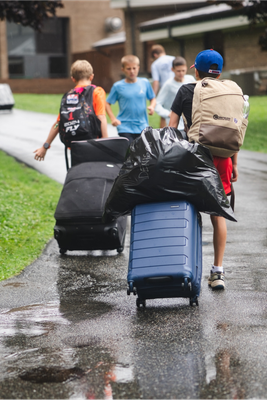 Campers arriving at camp with backpacks and rolling suitcases