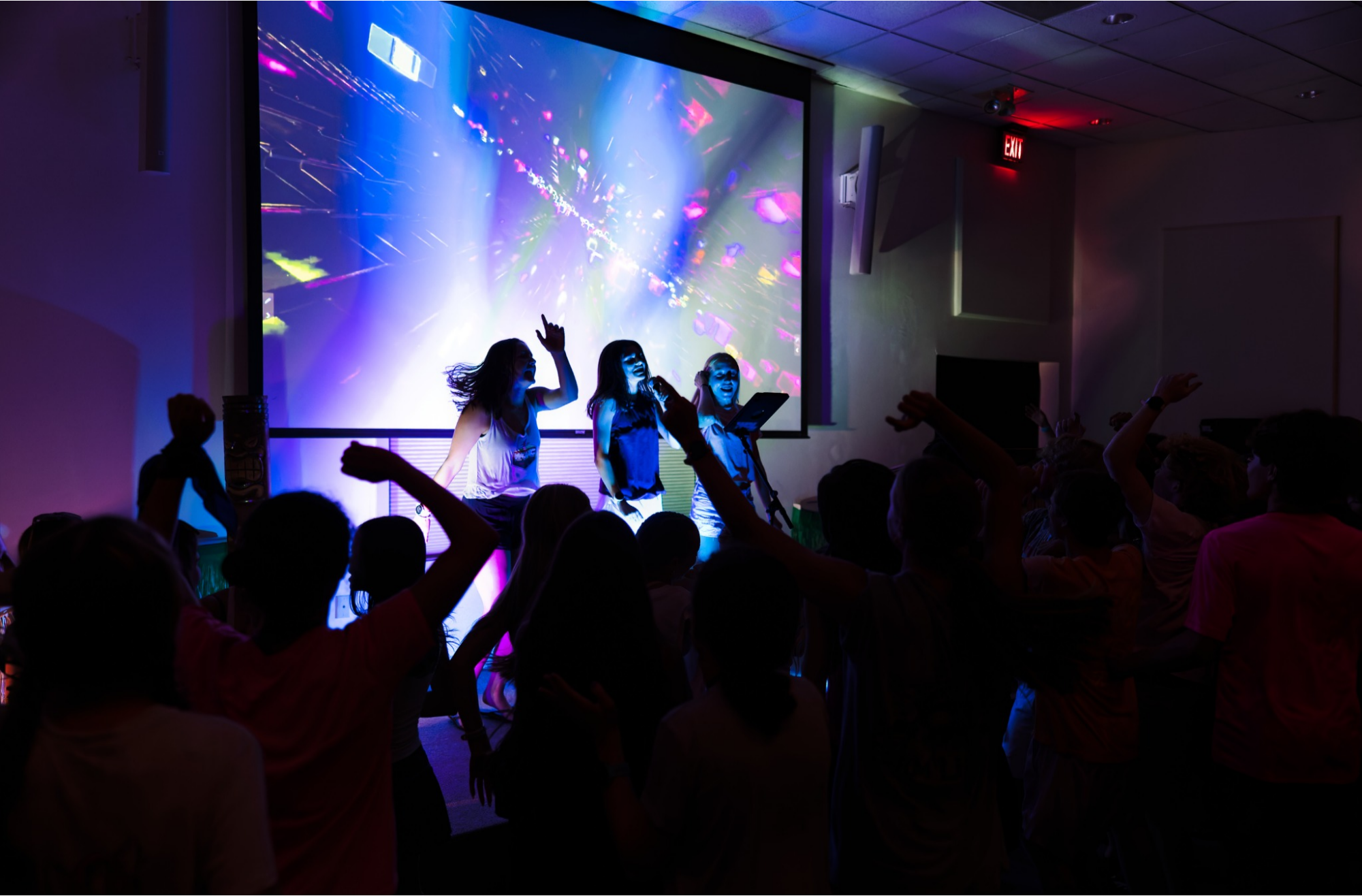 Campers performing karaoke while other campers cheer them on