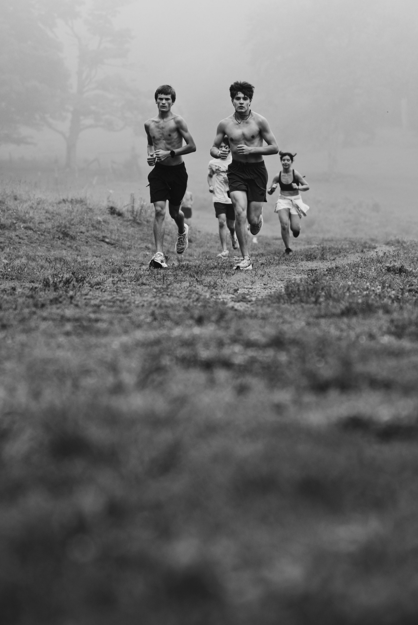 Campers running together on a misty mountain trail