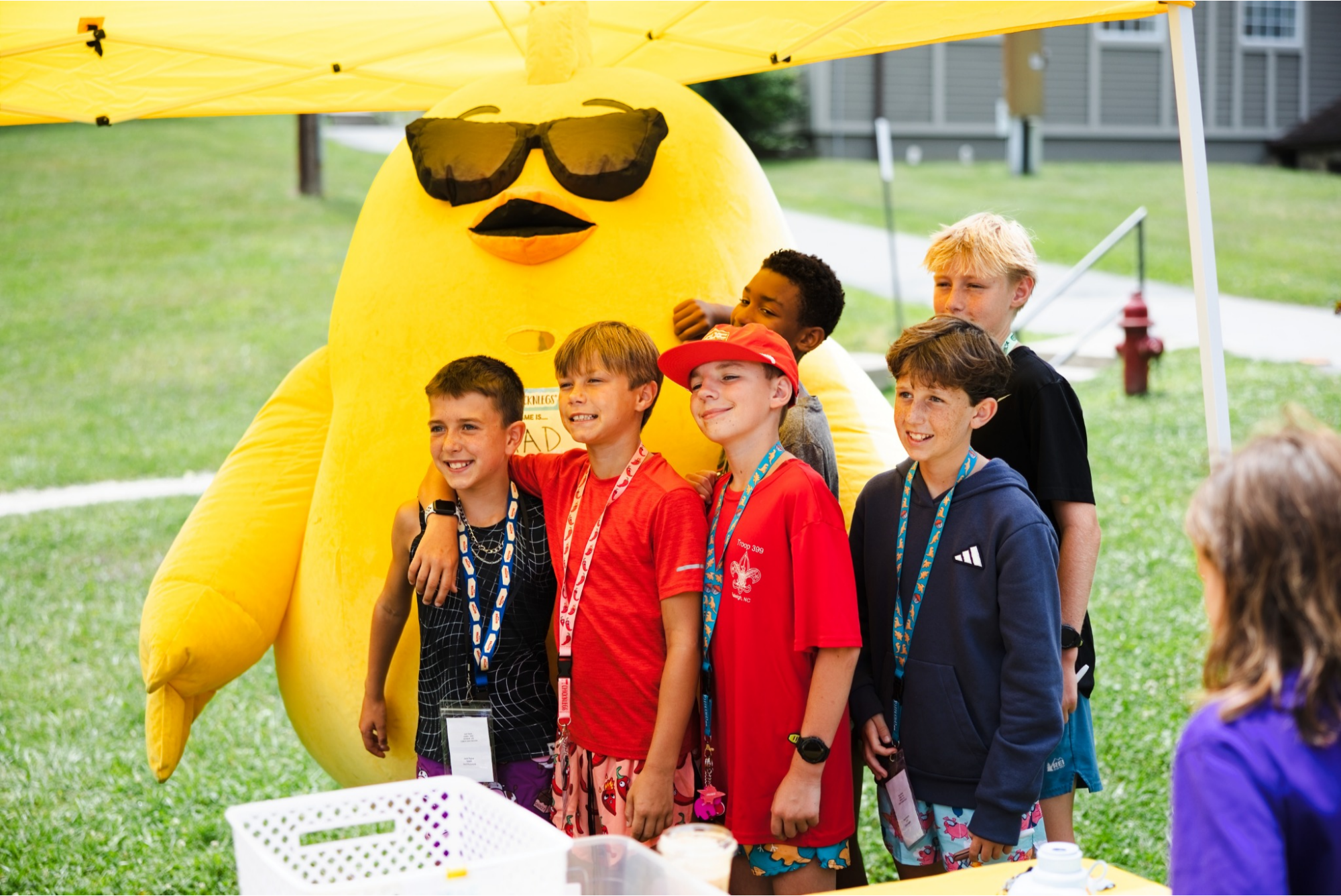 Campers pose with the ChicknLegs mascot at a gear event