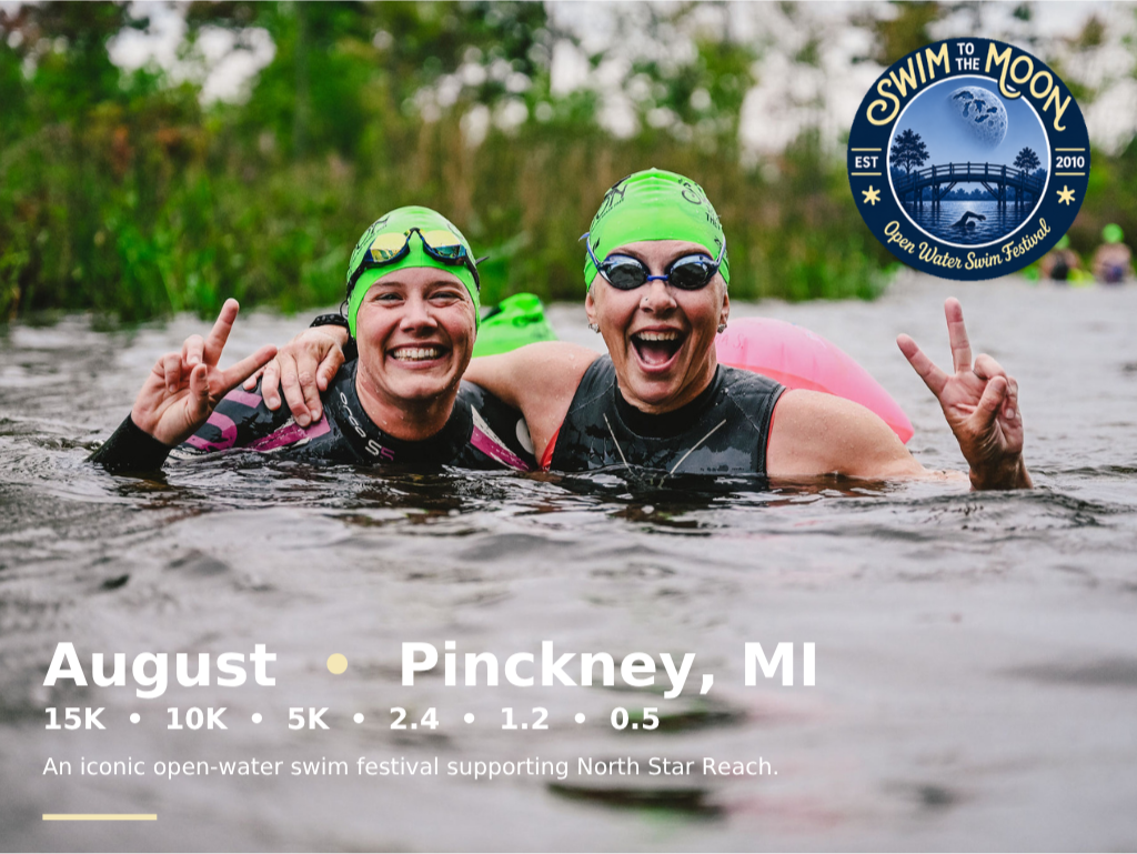 Smiling swimmers embracing each other while giving peace signs in the waters of Halfmoon Lake in Pinckney, Michigan during the annual Swim to the Moon Open Water Swim Festival